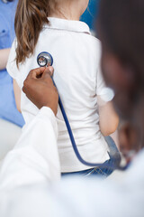 Close-up image of a doctor listening to heartbeat of a child with stethoscope. At doctor...