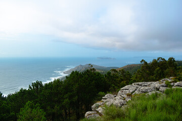 Fototapeta na wymiar Panoramic view from the mountain of the coast of Baiona and Cabo Silleiro with the Cies Islands in the background on a cloudy day. Baiona - Spain