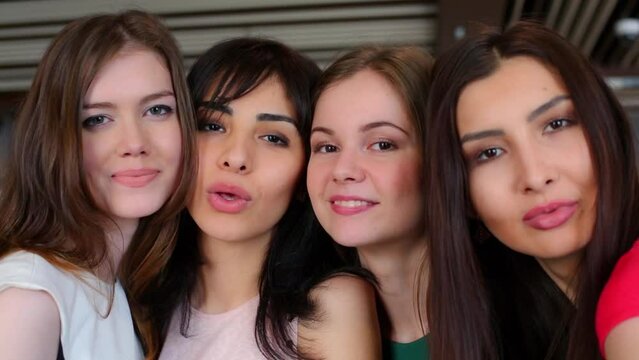 Faces of four young women which smiles close together