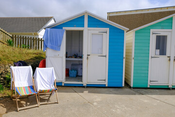 Bude, Cornwall, UK. Typical beach hut for hire in England with two deck chairs on a hot summer day