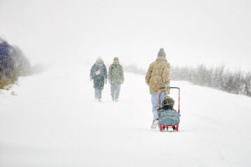 Group of People Walking Down a Snow-Covered Road During Winter Snowstorm