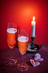 two glasses of champagne and a burning candle
