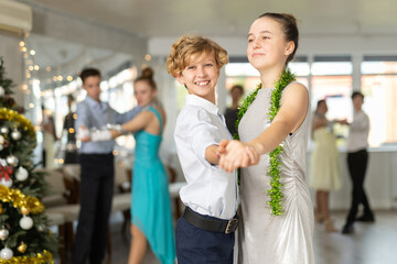 With unhurried music, teen boy and girl in couple spins to rhythm of tango during lesson for novice...