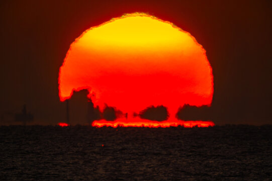 海から尖り帽子に歪んで昇る朝日20240105