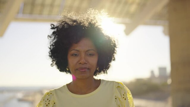 Video zooming out of a proud african woman looking at camera standing outdoors