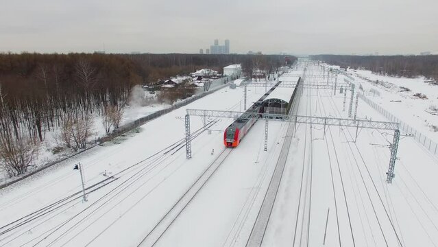 Passengers train Lastochka rides from station and cityscape