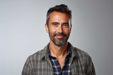 Handsome middle-aged man in a plaid shirt on a gray background