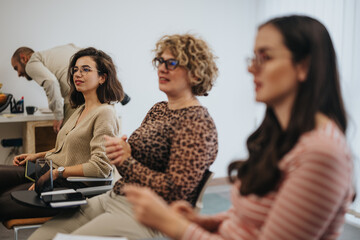 Engaged participants at interactive workshop listening attentively in office.
