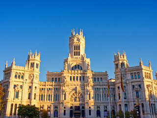 Madrid, Spain - November 19, 2023: Cibeles City Hall Palace in gold colors before sunset under clear sky