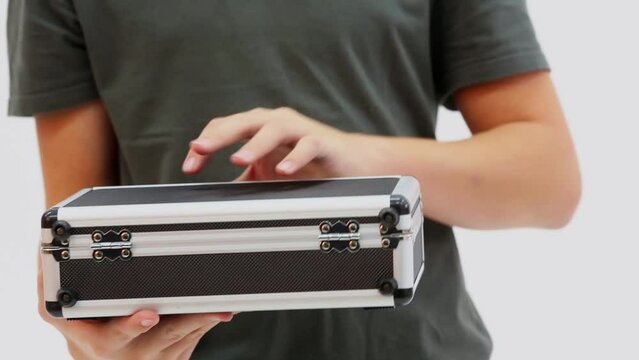 Young boy holds small case, opens it and then closes
