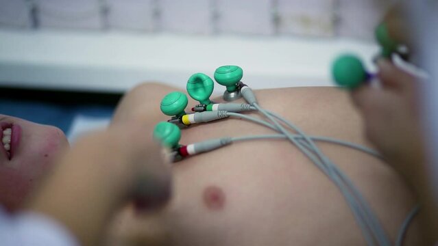 Probes with wires and suckers are on chest of young patient