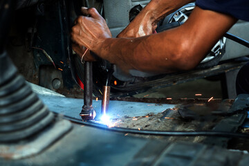 Close up of welding auto body with gas torch at auto repair shop