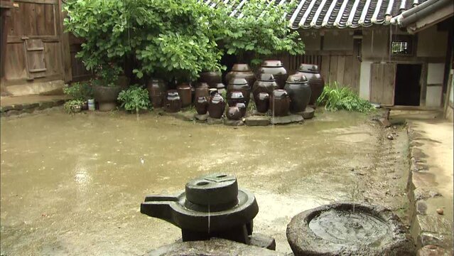 돌 물받이에 빗물이 떨어지는 한국적인 모습과 장독대
