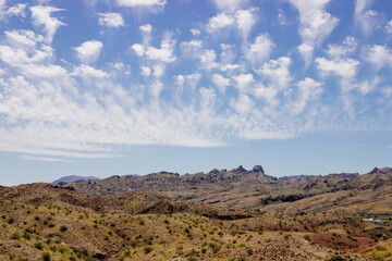 Beautiful blue sky with fluffy clouds over a desert with mountains in Arizona, USA. Panorama with high hills. Landscape on a sunny day