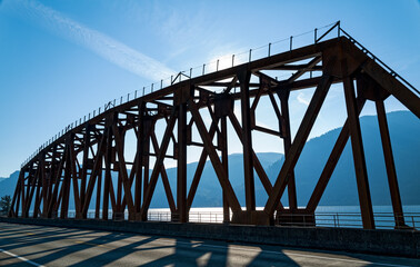 Silhouette of a railroad bridge curving along the banks of the Columbia River near Cook,...