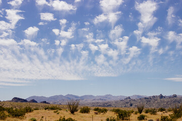 Beautiful blue sky with fluffy clouds over a desert with mountains in Arizona, USA. Panorama with high hills. Landscape on a sunny day