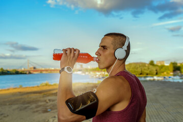 Handsome athlete drinking water after training. Photo of a young man drinking water .Water is a key to good workout.