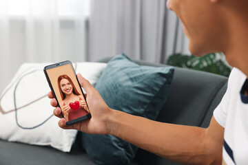 Long distance love. Man having video chat with his girlfriend via smartphone at home, closeup