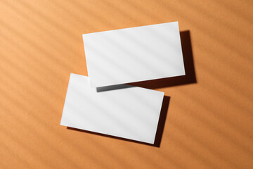 Empty business card on light brown background, top view. Mockup for design