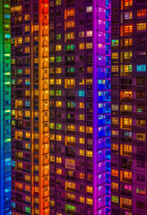 Artistic urban night scene with a spectrum of neon lights on a high-rise, perfect for modern city life content.