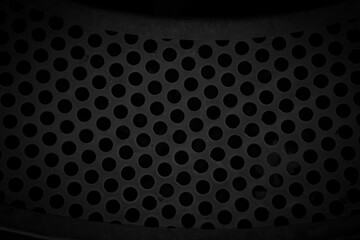 abstract background of black perforated metal with holes in it