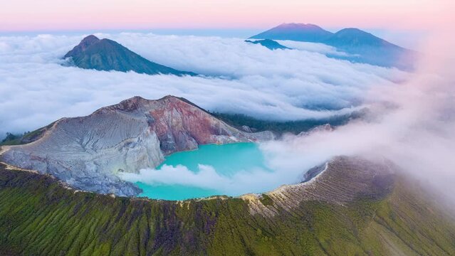 Aerial view Drone shot of fog at Kawah Ijen volcano with turquoise sulfur water lake and sunrise light.Amazing nature landscape view at East Java,Indonesia.Beautiful light Natural landscape background