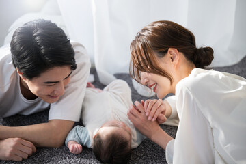 Obraz na płótnie Canvas 寝そべるアジア人（日本人）の赤ちゃんと親子の俯瞰