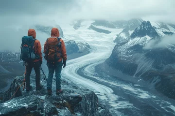 Foto op Plexiglas Amidst the snowy peaks, two brave hikers stand in awe of the glacial river below, guided by the misty mountain guide and equipped for their thrilling winter adventure © Martin