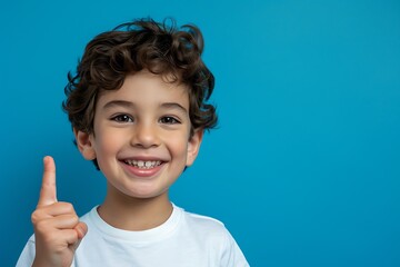 portrait of smiling positive young man holding finger up isolated on blue background