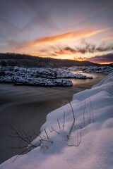 A colorful long, exposure, sunrise at Great Falls along the Potomac River after a fresh snowfall.
