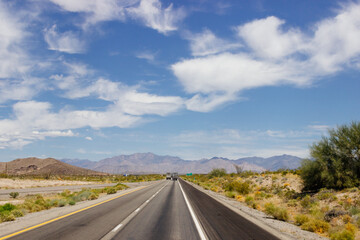 Beautiful blue sky with fluffy clouds over the highway. Scenic road in Arizona, USA on a sunny summer day. 40 hwy, 10 hwy in Arizona, USA - 17 April 2020