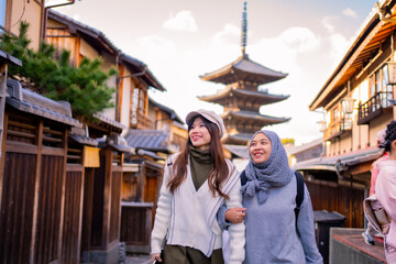 Travel, muslim travel,  woman girl tourist Two Asian friends but different religions walking at Yasaka Pagoda and Sannen Zaka Street in Kyoto Japan, Yasaka Pagoda is the famous landmark and travel.