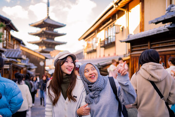 Fototapeta premium Travel, muslim travel, woman girl tourist Two Asian friends but different religions walking at Yasaka Pagoda and Sannen Zaka Street in Kyoto Japan, Yasaka Pagoda is the famous landmark and travel.