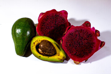 two pieces of dragon fruit and avocado, served on a plain white background
