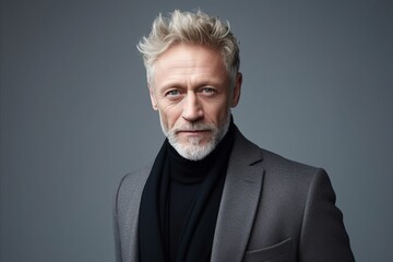 Portrait of handsome mature man in grey coat and turtleneck.
