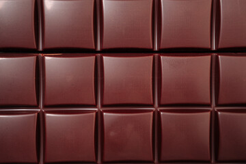 Dark chocolate background with raised rectangular texture with shiny highlights and dark shadows