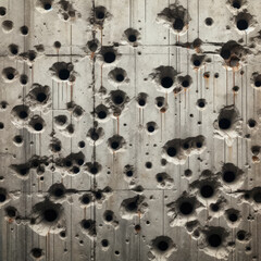 a weathered cement wall with multiple bullet holes