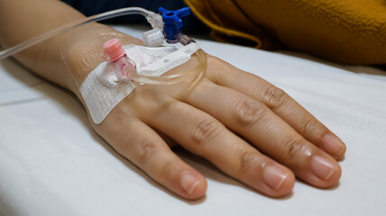 Close up of a patient's hand getting vitamin or medicine solution through IV line infusion while...