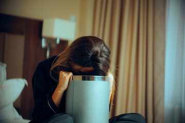 Sick Woman Vomiting into a Trash Bin at Home. Pregnant girl suffering from morning sickness symptoms. 
 - obrazy, fototapety, plakaty