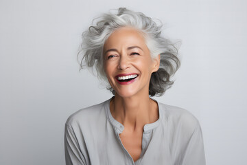 middle-aged woman in her 40s, with white gray hair, smiling beautifully as a skin care product model - obrazy, fototapety, plakaty