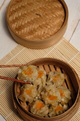 Delicious dimsum or siomay on bamboo steams. dimsum or dumpling is a snack from China and Hong Kong. Dimsum is made from chicken, pork, shrimp, squid, tapioca flour, and seasonings. Wonton dumpling. 