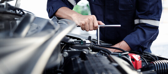 Mechanic are using the wrench to repair and maintenance auto engine at car repair shop,Car auto...