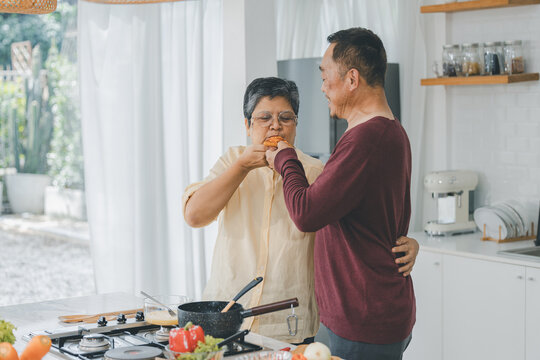 Couple Senior Asian Elder Happy Living In Home Kitchen. Elderly Couple Cooking In A Kitchen. Happy Mature Couple Family Together In The Kitchen, Active Seniors. Older People Relationship And Activity.