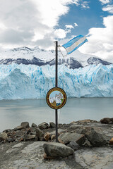 Bandeira da Argentina e placa no parque nacional los glaciares e ao fundo montanhas com neve e o...