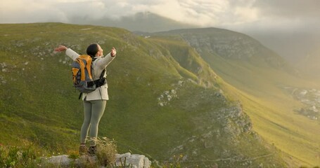Woman, mountain top and freedom, trekking goals, celebration or travel achievement in nature adventure. Person or winner in backpack with arms up for hiking success, energy and yes on a cliff or rock