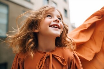 Portrait of a cute little girl in an orange raincoat.