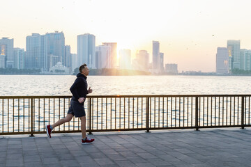 Morning run, a man runs along the waterfront with a beautiful view of Shurjah, UAE.