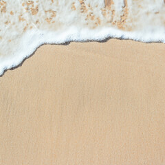 Abstract sand beach from above with light blue transparent water wave and sun lights.