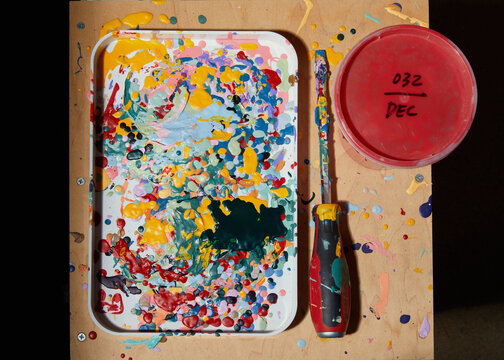 Silk screen artist's paint splattered on tray with tools