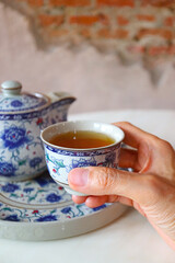 Closeup of Hand Holding a Cup of Hot Chinese Tea